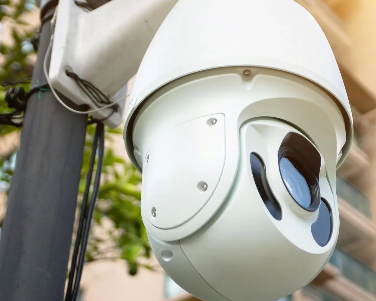 Close up of a PTZ security camera mounted on a commercial building
