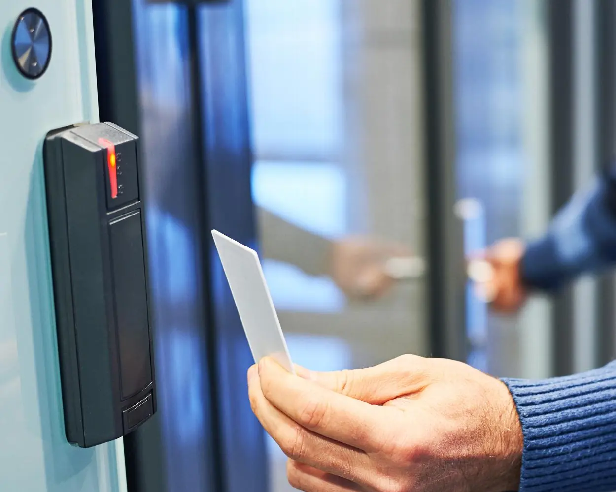 Person presenting a card to an access control reader on an office door