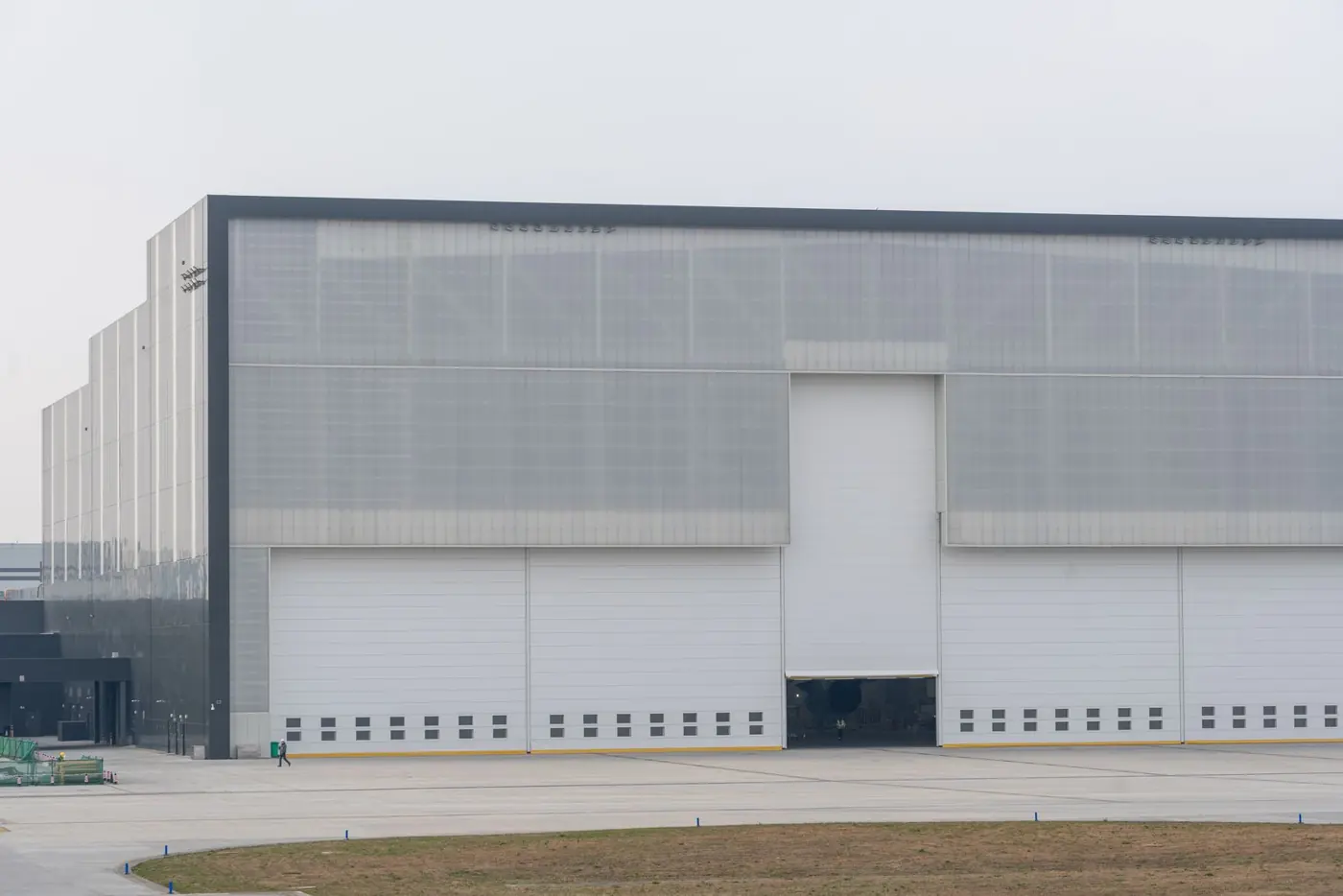 Exterior of a large modern logistics warehouse with loading doors and yard