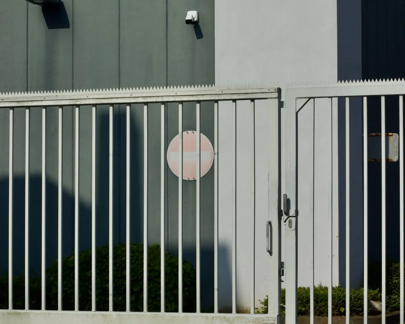 White steel security fence and gate around an industrial building